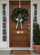 Load image into Gallery viewer, Green wreath with a decorative bow on a white door